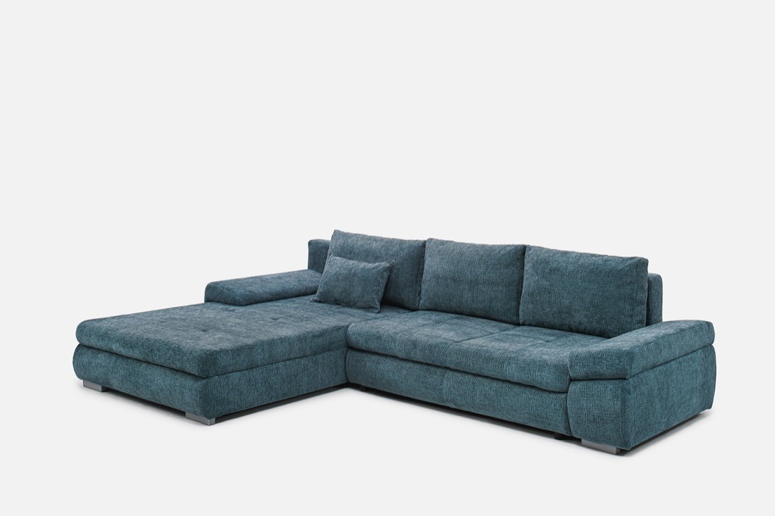 Tirkizna ugaona sofa fotografirana u studiju na bijeloj pozadini