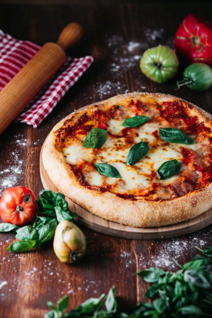 Pizza Margherita sa svježim bosiljkom na tamnoj drvenoj podlozi