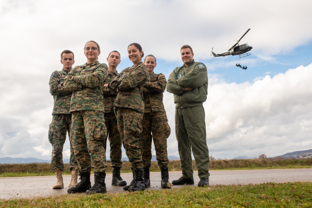 Grupni portret vojnog osoblja s helikopterom u pozadini