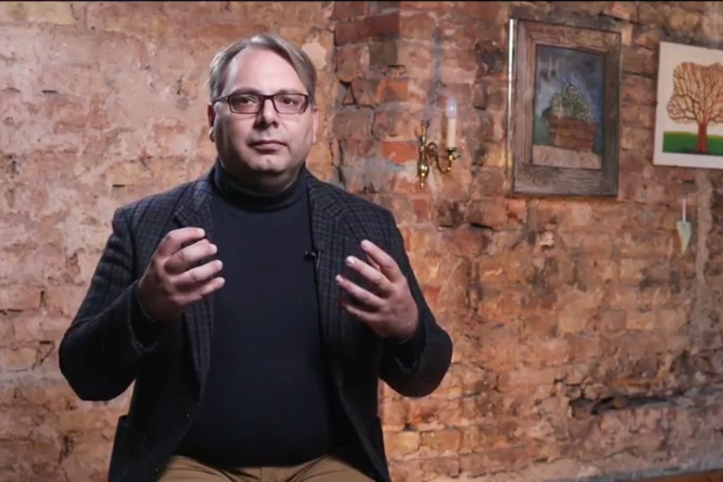 Intervju s muškarcem ispred zida od stare cigle u toplom osvjetljenju